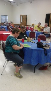 Pastor Ray Spitzenberger and Maxine Cates (foreground) , Steve and Don Trojacek (background), and Nicole and Aubrey Brzozowski (distant background) concentrating on Bingo cards.