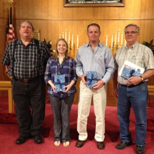 Steve Grissom, St. Paul Head Elder, presents a gift Bible from the congregation to new members joining the church, -- Cole and Amelia Hegefeld and Don Trojacek.
