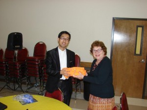 Rev Kim presents the Sunday School Superintendent with some special T-shirts for the kids.