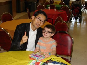 Dylan is pictured showing Rev. Dr. David Kim the books from his Sunday School class.