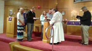 Left to right, Amanda Nielson (sponsor), Clint Hegefeld (sponsor), Amelia Hegefeld (mother) with baby Bentlee, Cole Hegefeld (father), Pastor Ray, and Jan Johnson (Congregational President) pictured during the Rite of Baptism on February 14, 2016.