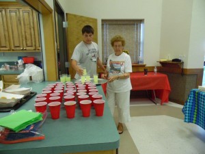 Seth is shown helping Annie Mae Korenek serve drinks at Vacation Bible School.