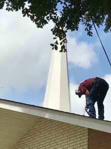 Gary Davis pictured putting the final touches on the steeple installation