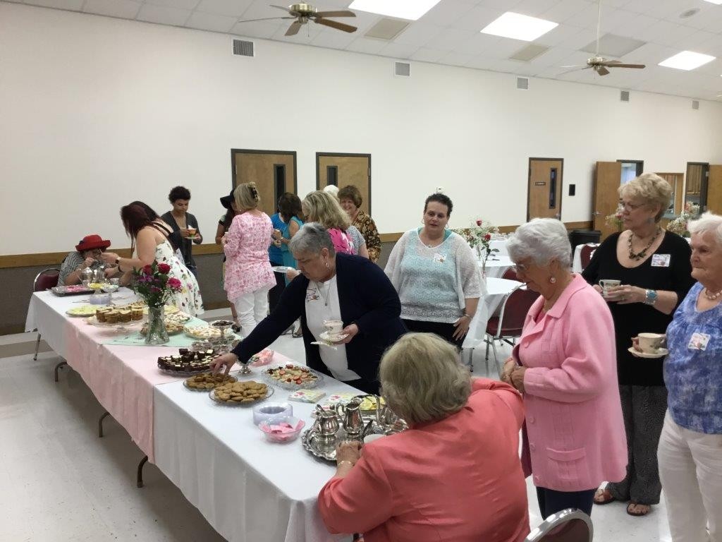 Peggy Spitzenberger, at one end of the table, and Caroline Osborne, at the other end, service tea to the ladies attending the LWML Ladies' Tea.